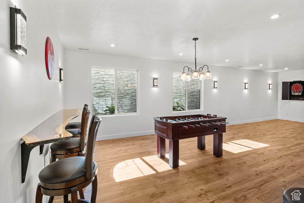 Rec room featuring baseboards, recessed lighting, light wood-style floors, and a chandelier