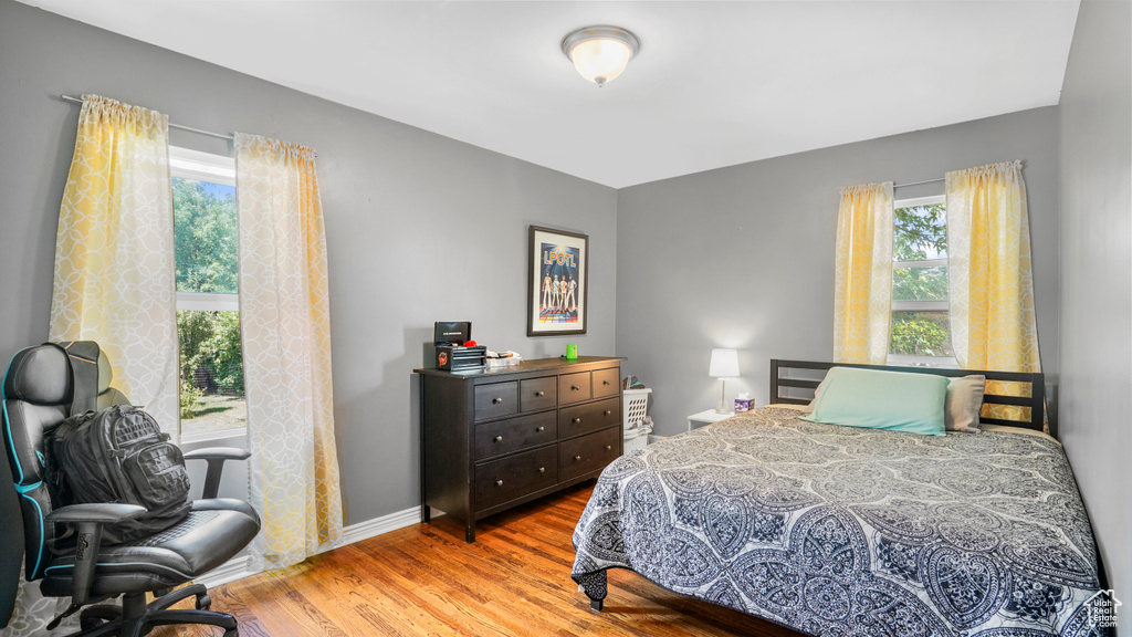 Bedroom with wood finished floors and baseboards