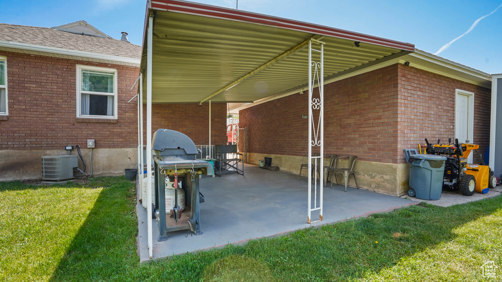 View of patio with cooling unit and a grill