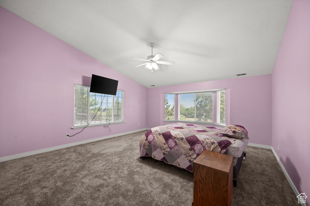Bedroom featuring carpet, vaulted ceiling, baseboards, and a ceiling fan