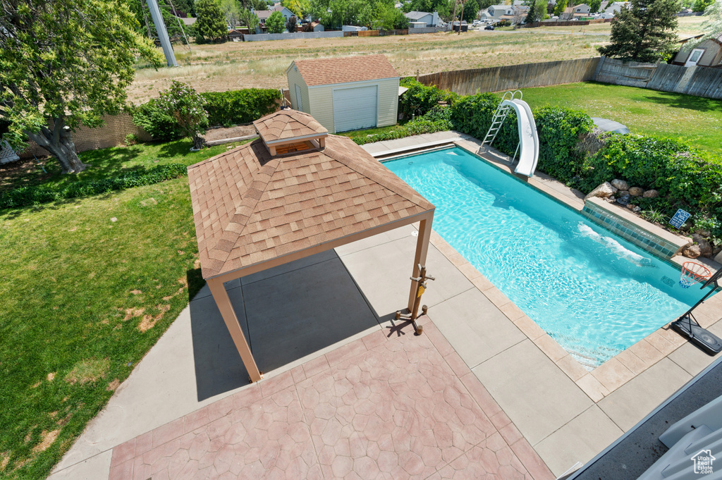 View of swimming pool featuring a water slide and a patio
