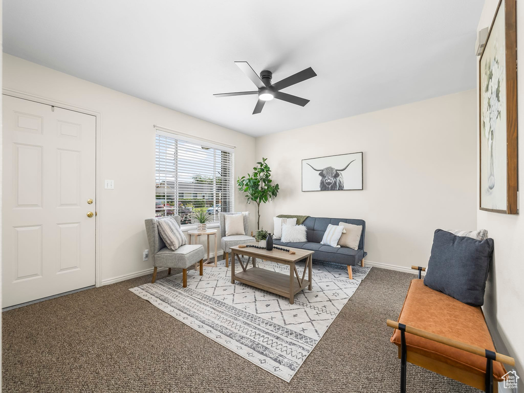 Living room with a ceiling fan, carpet floors, and baseboards