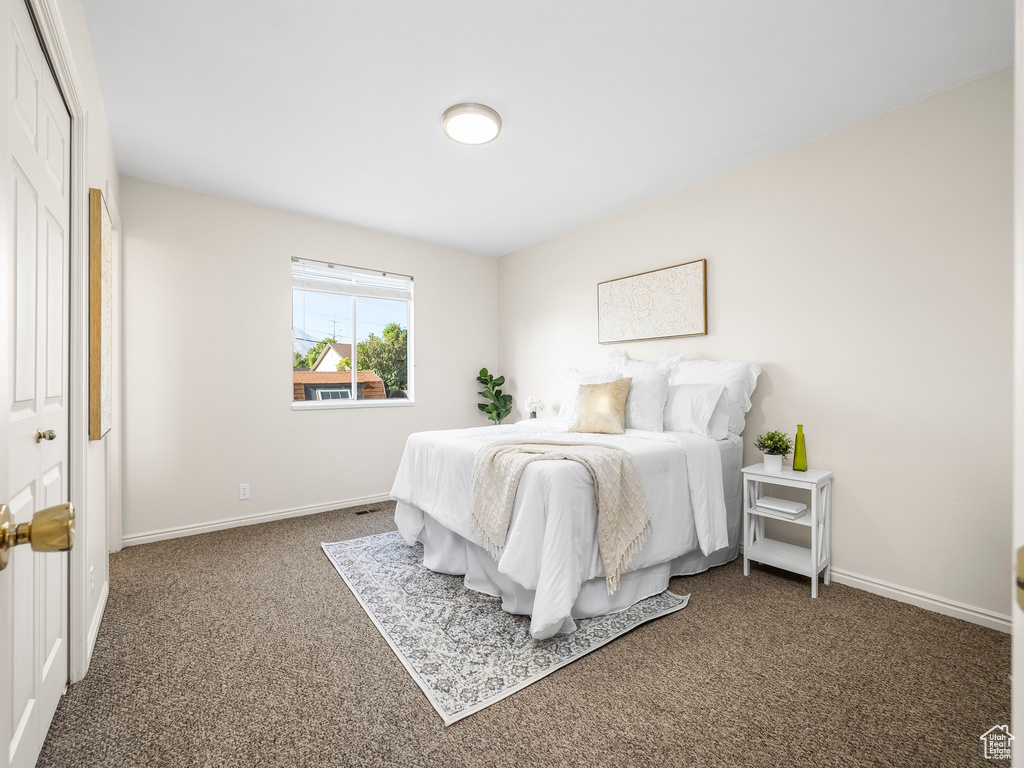 Bedroom featuring carpet and baseboards