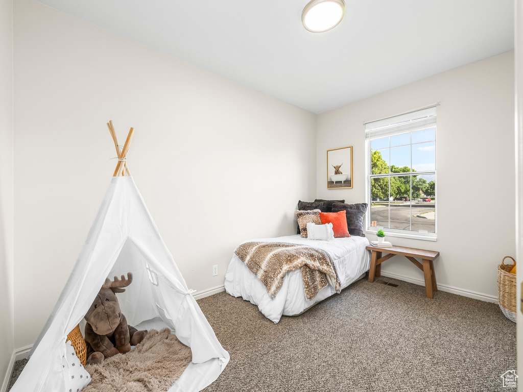 Bedroom featuring carpet floors and baseboards