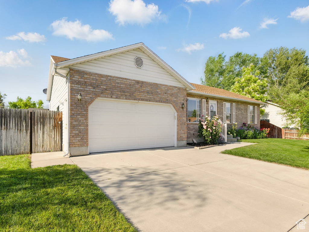Ranch-style house with an attached garage, concrete driveway, and brick siding