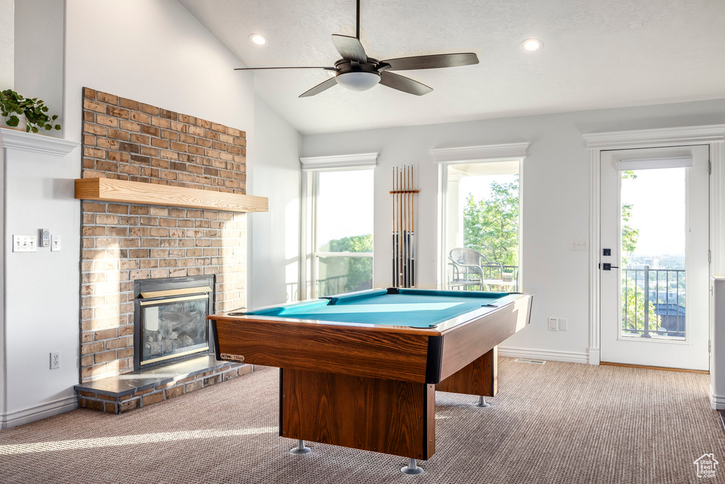 Recreation room featuring carpet floors, lofted ceiling, a fireplace, a ceiling fan, and billiards
