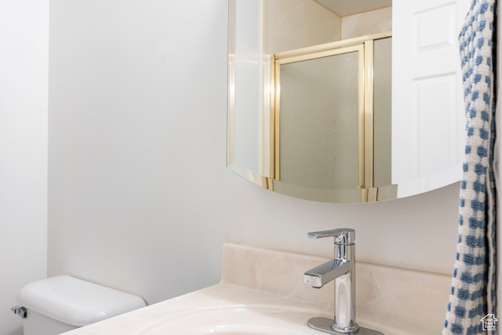 Bathroom featuring toilet, an enclosed shower, and vanity