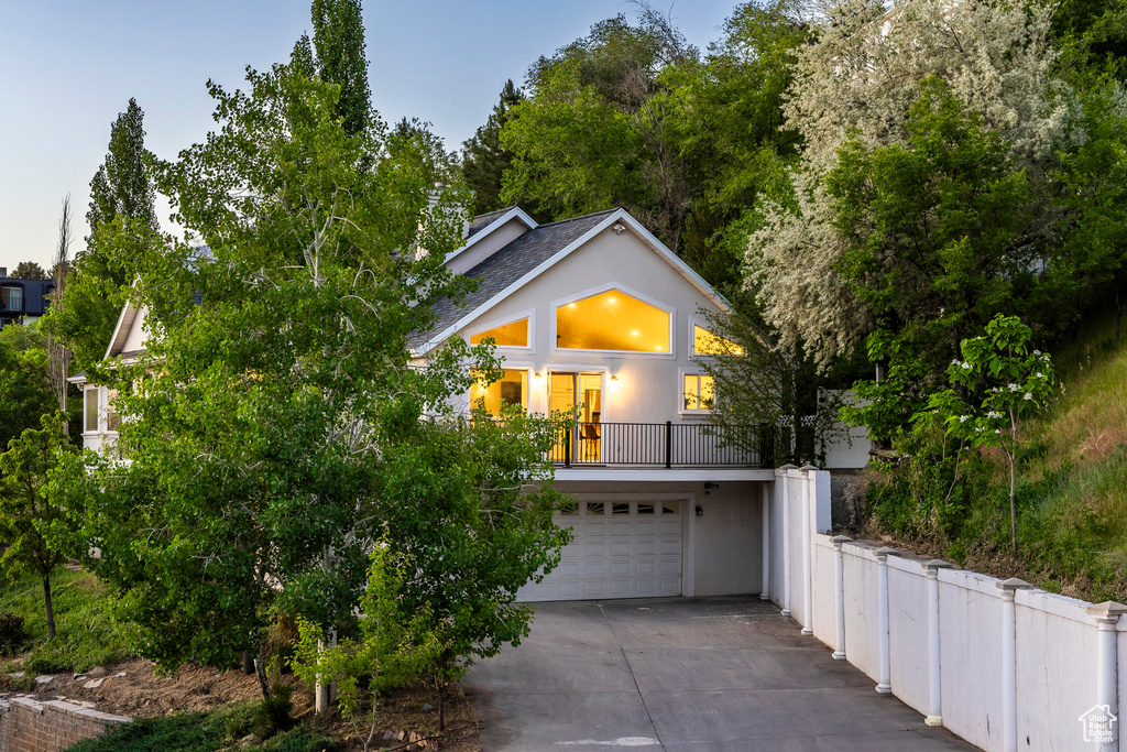 View of front of house featuring stucco siding, driveway, and a garage
