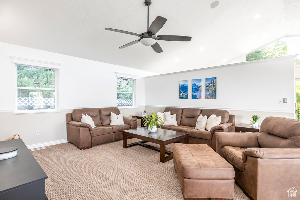 Living room featuring lofted ceiling, ceiling fan, and baseboards