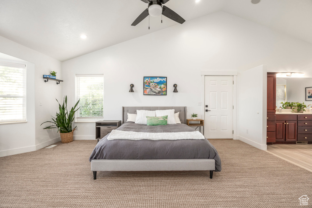 Bedroom with high vaulted ceiling, light carpet, recessed lighting, baseboards, and connected bathroom