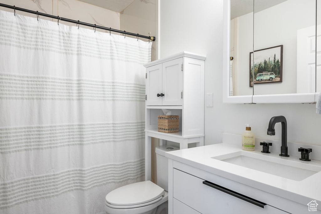 Bathroom featuring vanity, toilet, and a shower with curtain