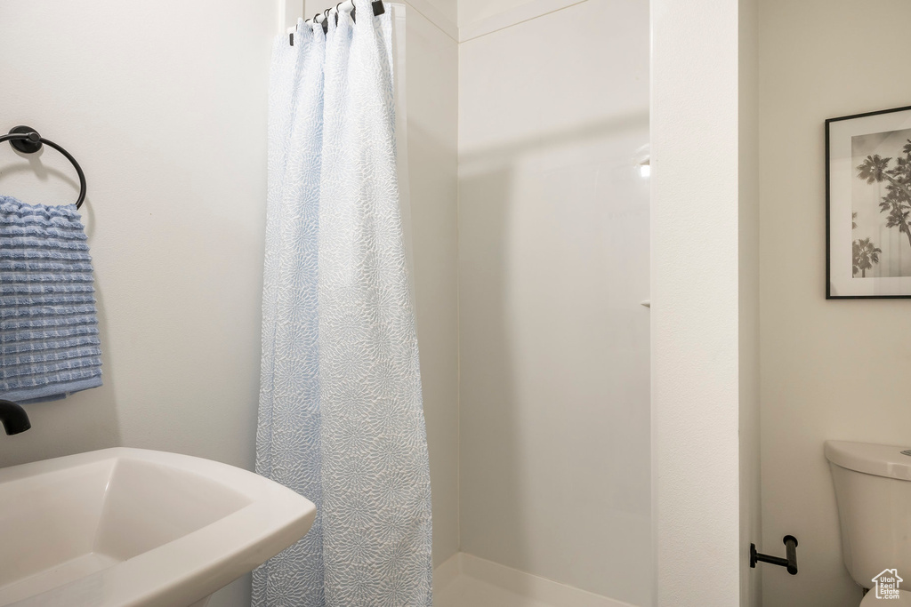 Full bathroom with a sink, a shower stall, and toilet