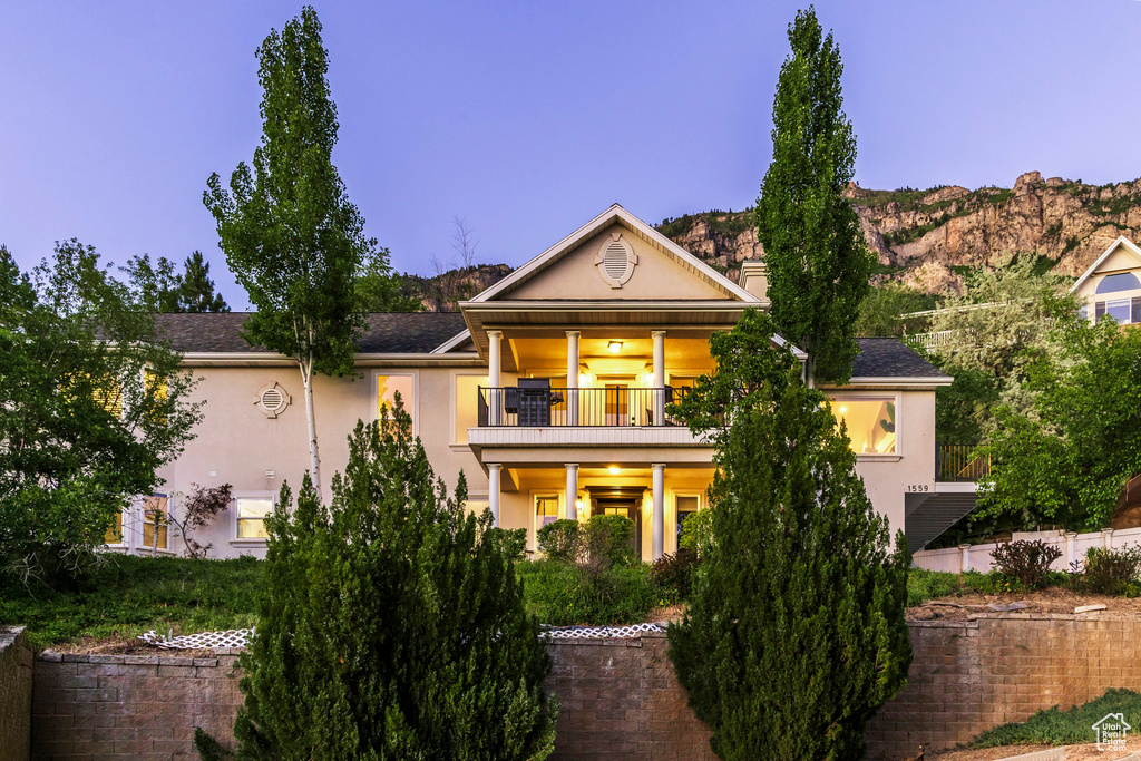 View of front of house with a balcony and stucco siding