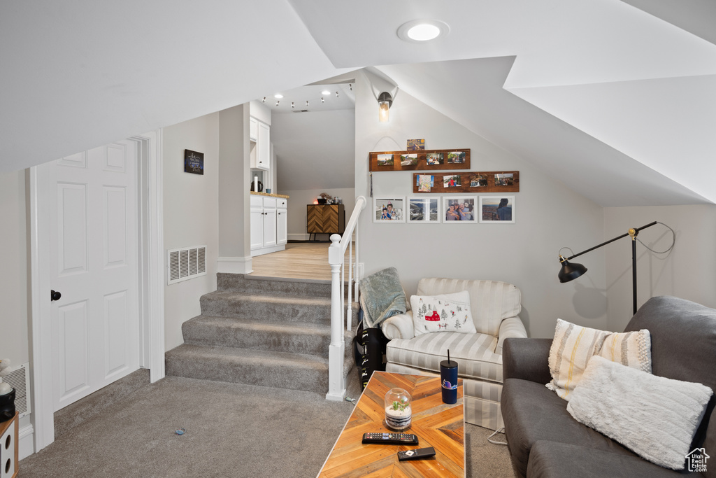 Living room featuring vaulted ceiling, stairway, and recessed lighting