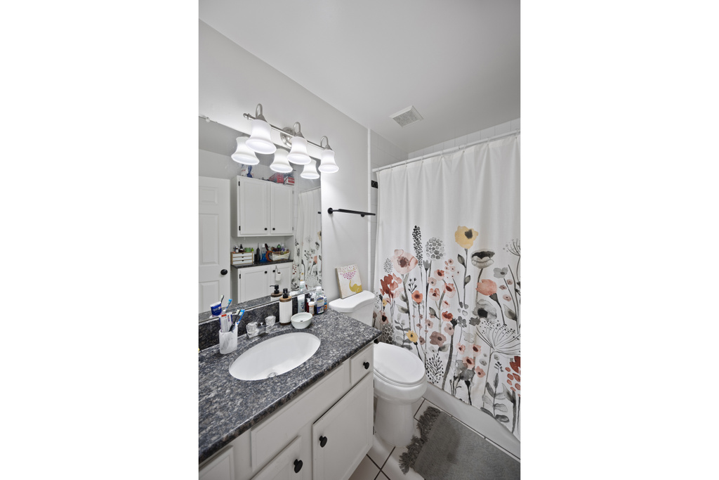 Bathroom featuring vanity, toilet, and tile patterned floors