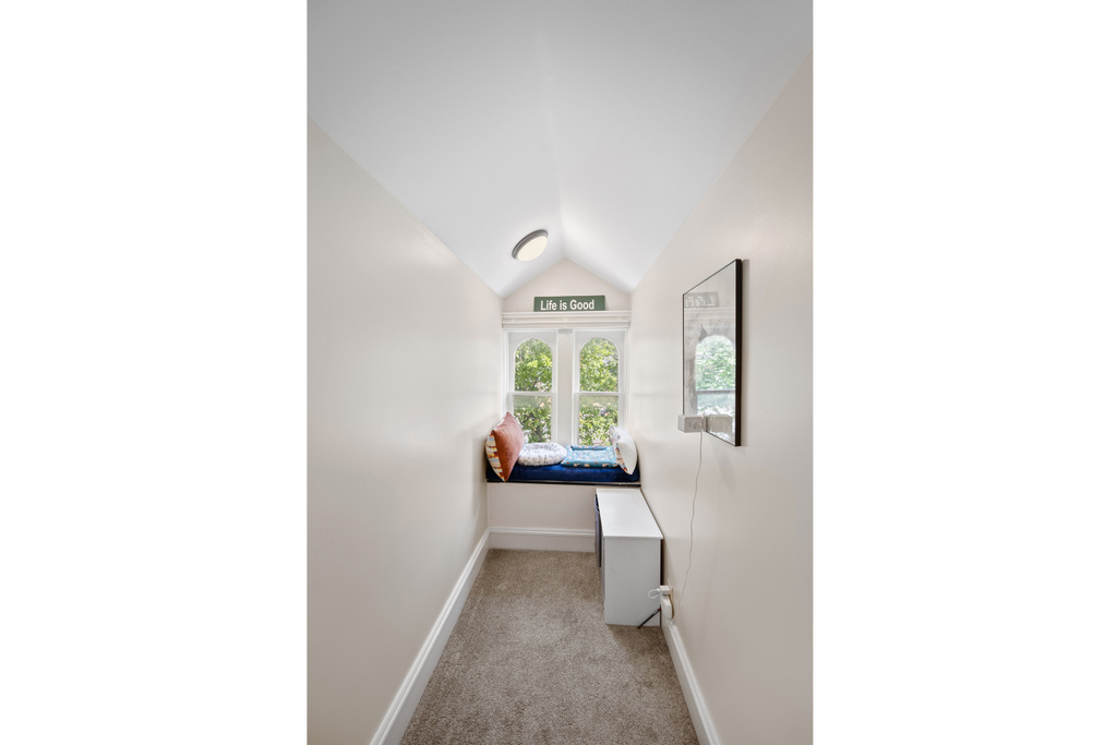 Corridor featuring lofted ceiling, carpet floors, and baseboards