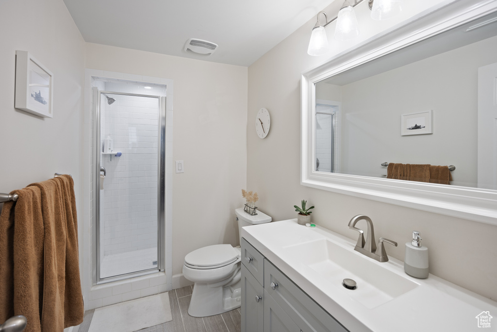 Full bath featuring toilet, vanity, and a stall shower
