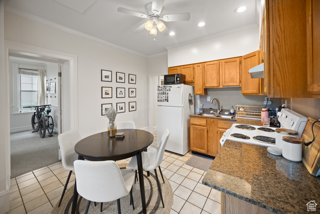 Kitchen featuring white appliances, a sink, under cabinet range hood, a ceiling fan, and light tile patterned floors