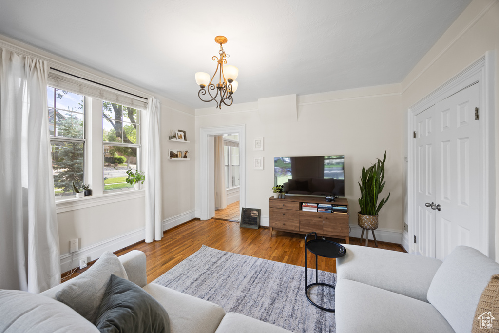 Living area featuring a chandelier, baseboards, and wood finished floors