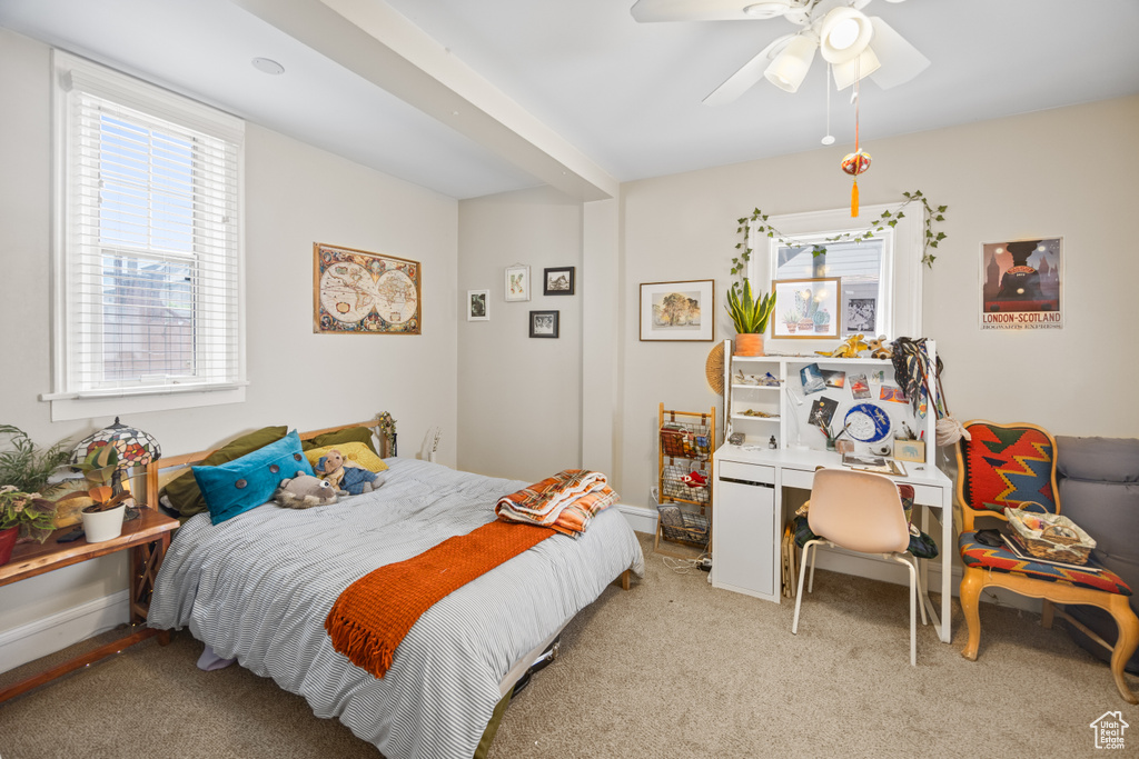 Carpeted bedroom featuring a ceiling fan