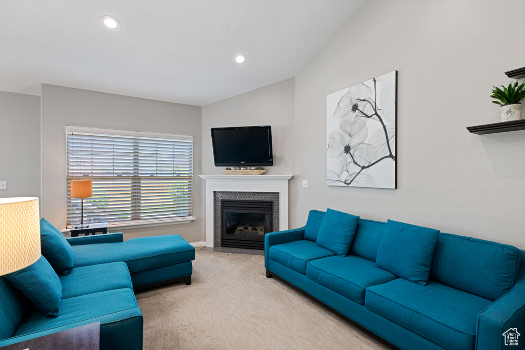 Living room featuring carpet flooring, vaulted ceiling, a tiled fireplace, recessed lighting, and baseboards