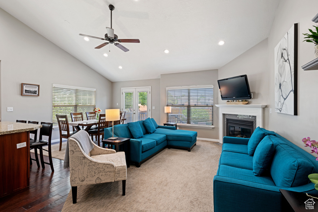 Living area with lofted ceiling, a glass covered fireplace, recessed lighting, a ceiling fan, and baseboards
