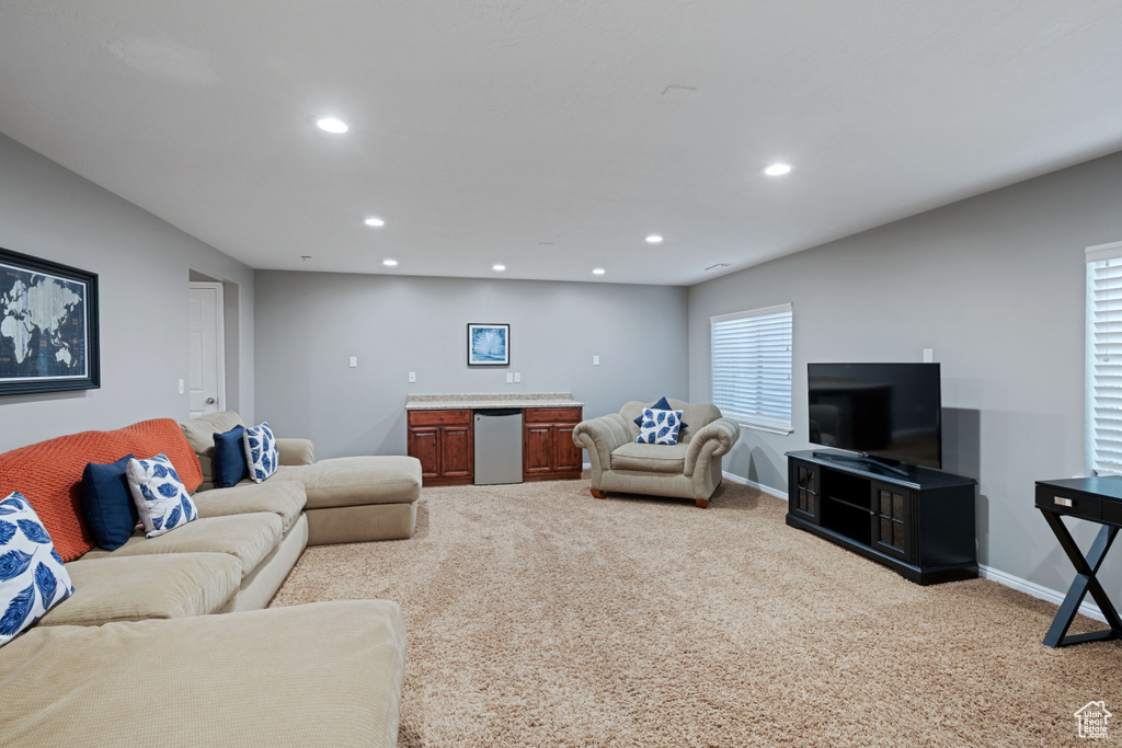 Carpeted living room featuring recessed lighting, baseboards, and bar area