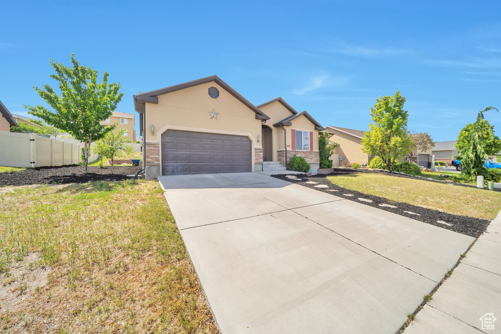 Ranch-style home with stucco siding, concrete driveway, and an attached garage