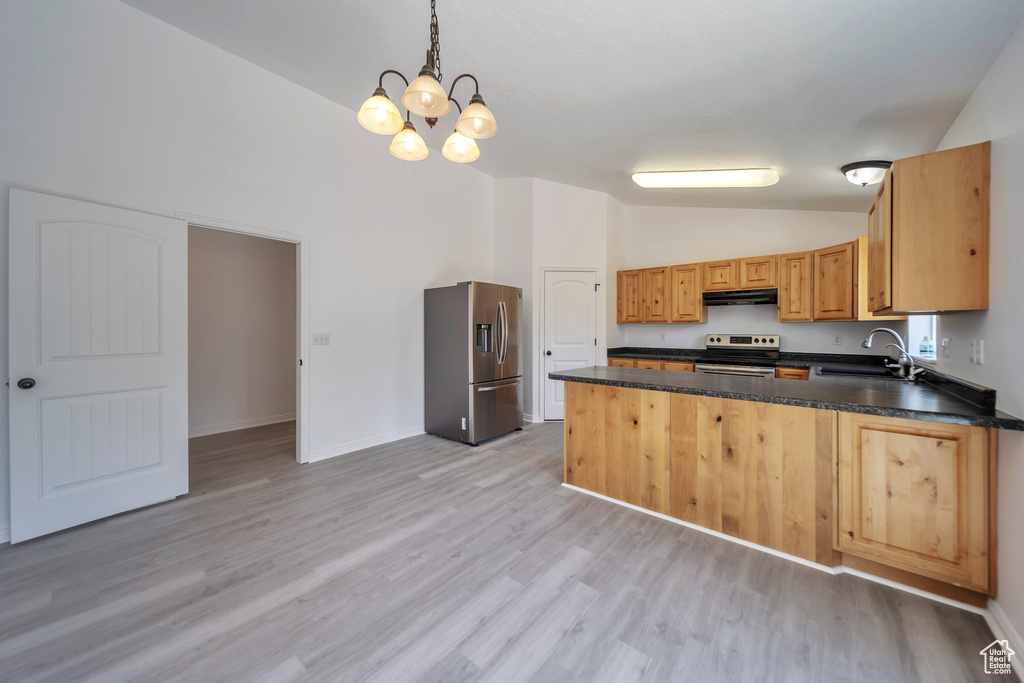 Kitchen with appliances with stainless steel finishes, vaulted ceiling, a sink, under cabinet range hood, and a peninsula