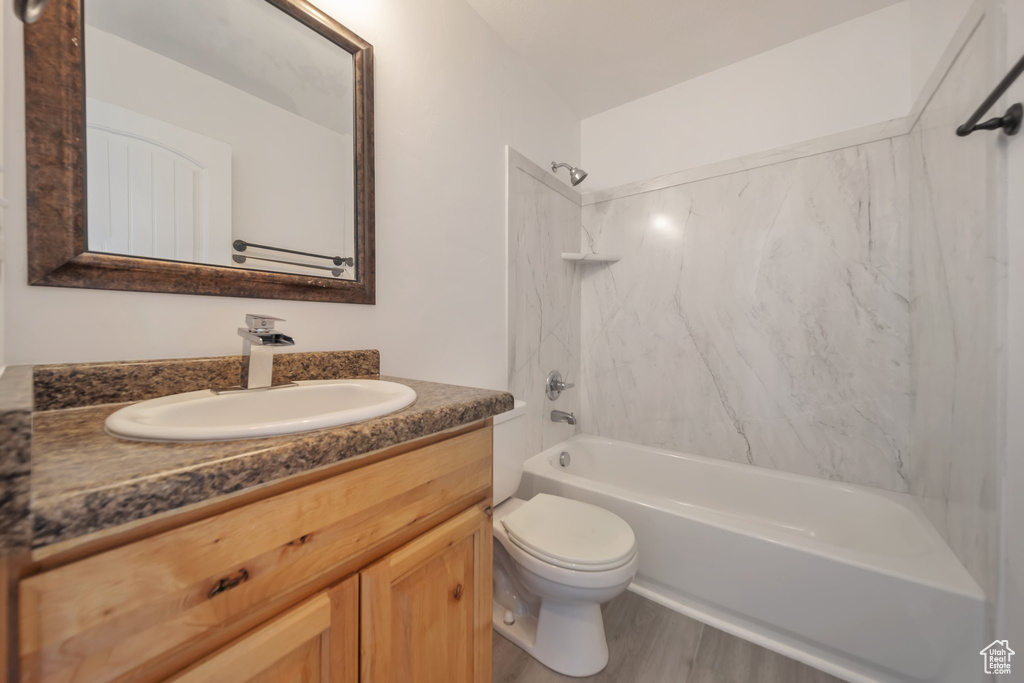 Full bathroom featuring bathing tub / shower combination, vanity, toilet, and wood finished floors