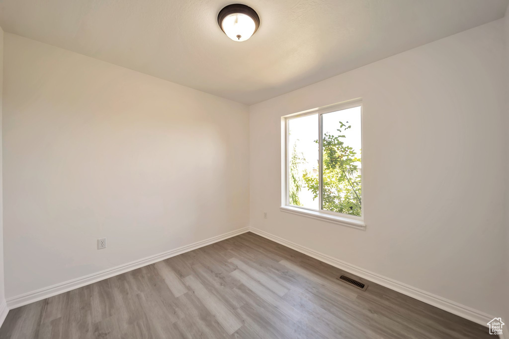 Spare room with baseboards and wood finished floors