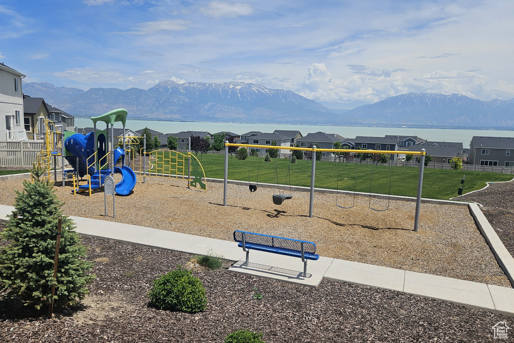 Community jungle gym with a mountain view, a residential view, and a lawn