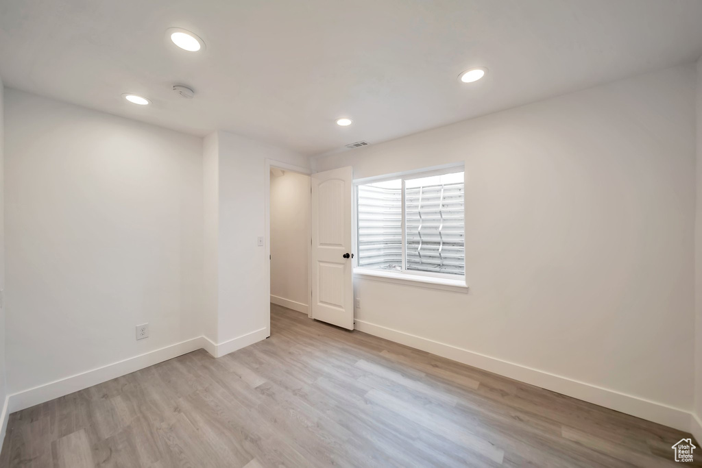 Spare room featuring baseboards, recessed lighting, light wood-style floors, and a smoke detector