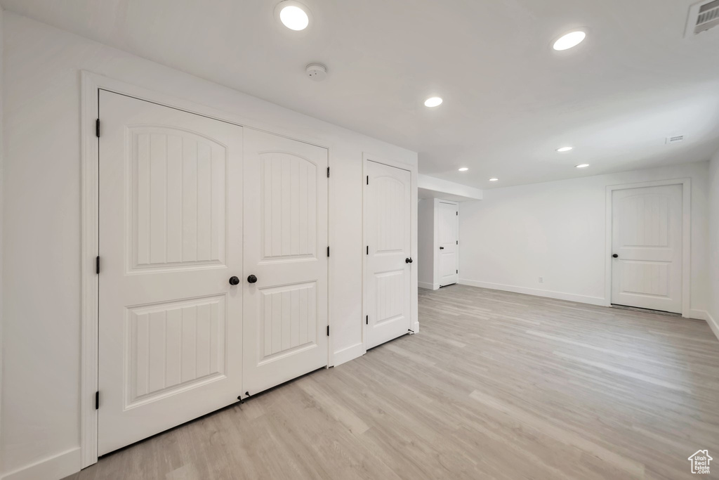 Finished below grade area with light wood-style flooring, recessed lighting, and baseboards