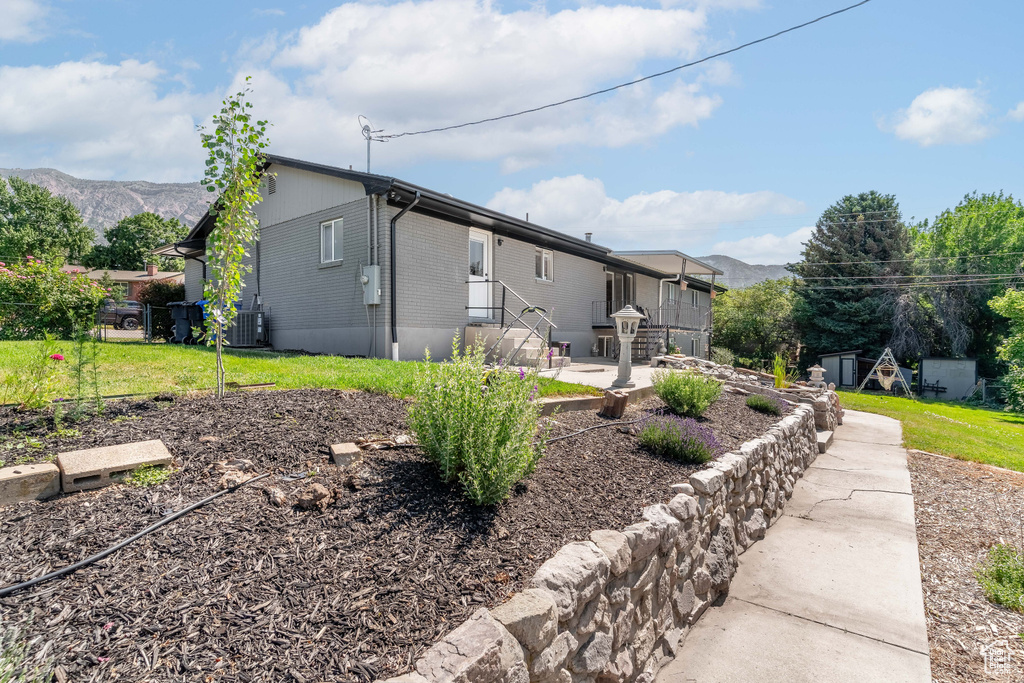 Rear view of house featuring a patio, central AC unit, and a mountain view