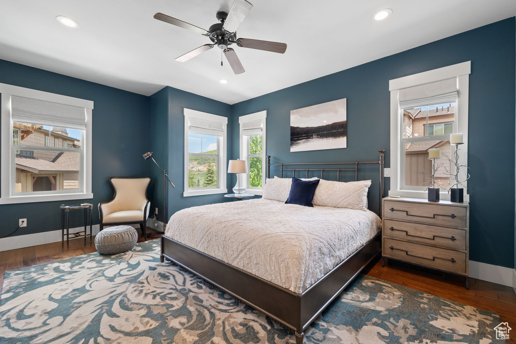 Bedroom featuring multiple windows, wood finished floors, baseboards, and recessed lighting