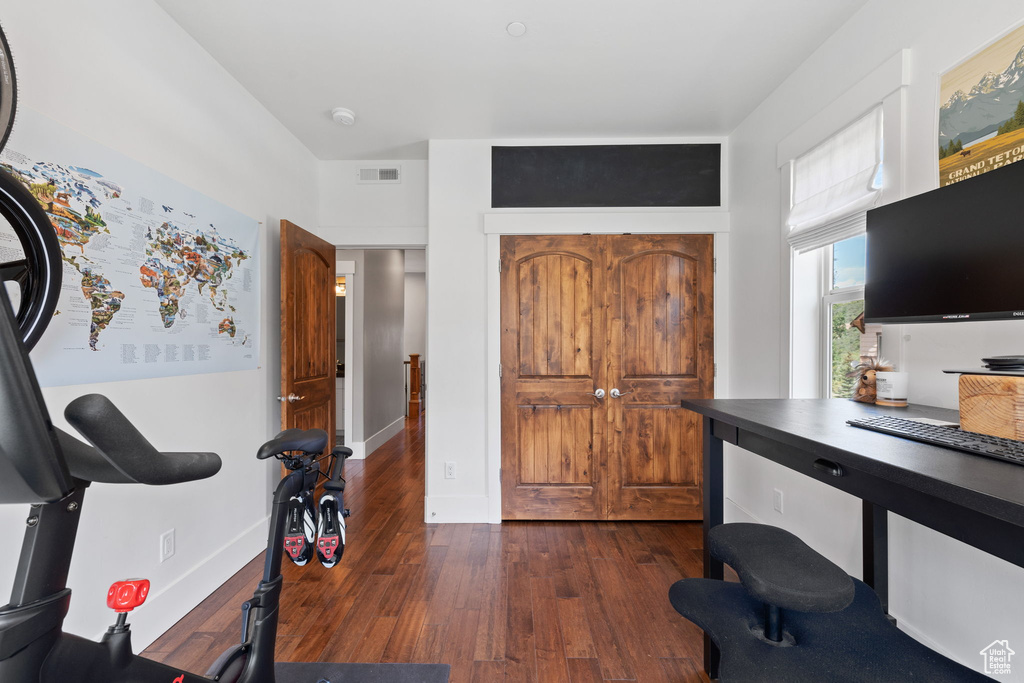 Office area featuring dark wood-type flooring and baseboards