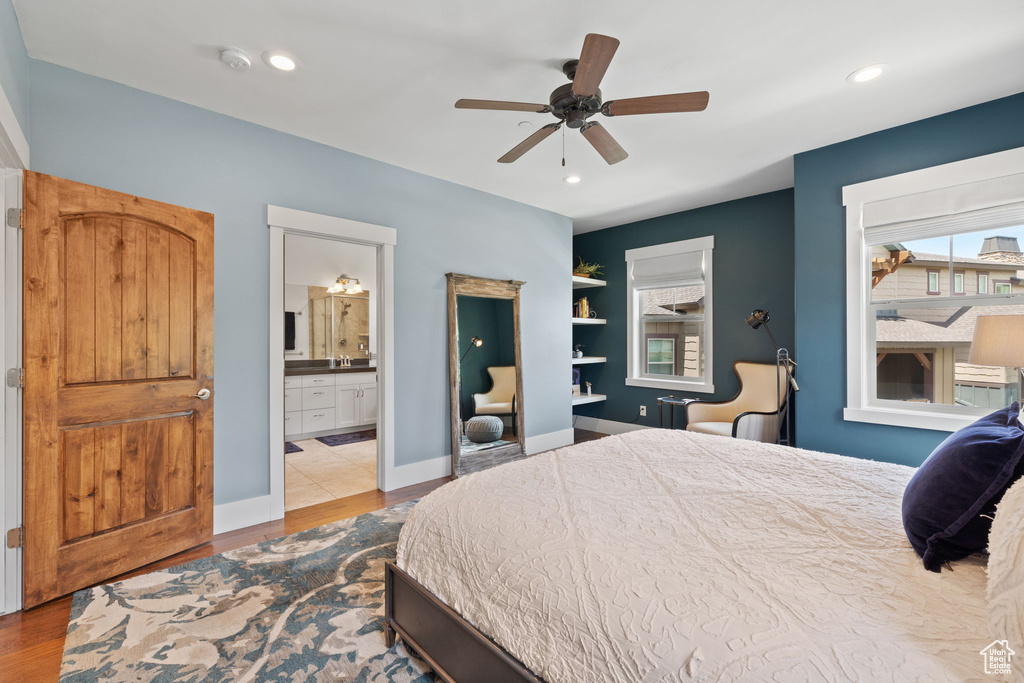 Bedroom with dark wood-type flooring, ensuite bath, recessed lighting, baseboards, and ceiling fan