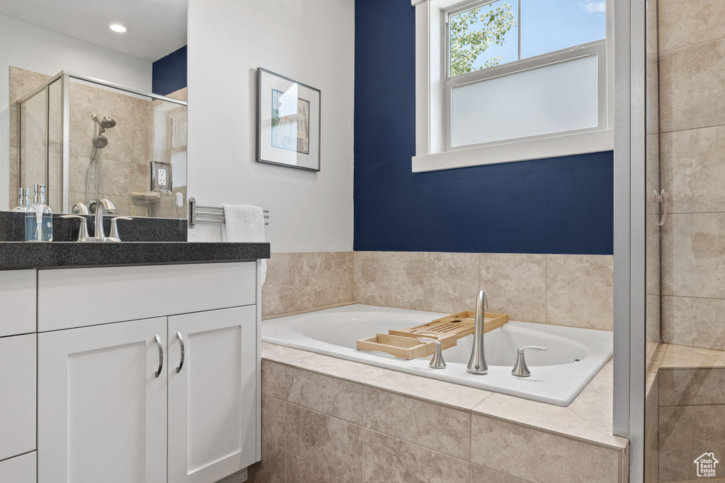 Full bathroom with vanity, a garden tub, and a shower stall