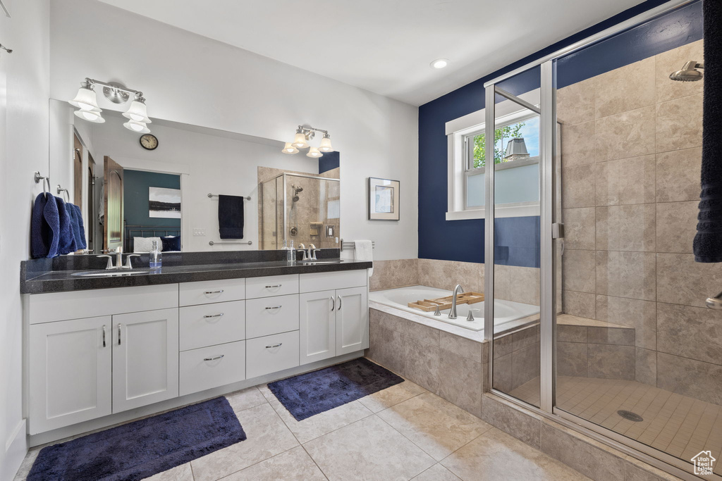Full bathroom with a shower stall, double vanity, tile patterned flooring, and a garden tub