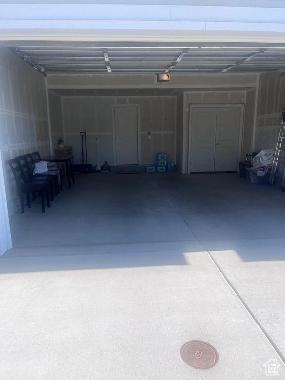 Garage featuring driveway and a garage door opener