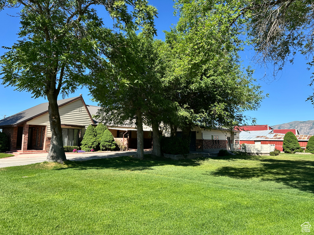 View of front facade featuring a front yard, brick siding, and driveway