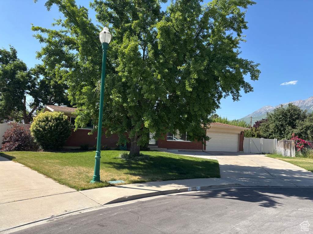 Obstructed view of property featuring driveway, a garage, and a mountain view