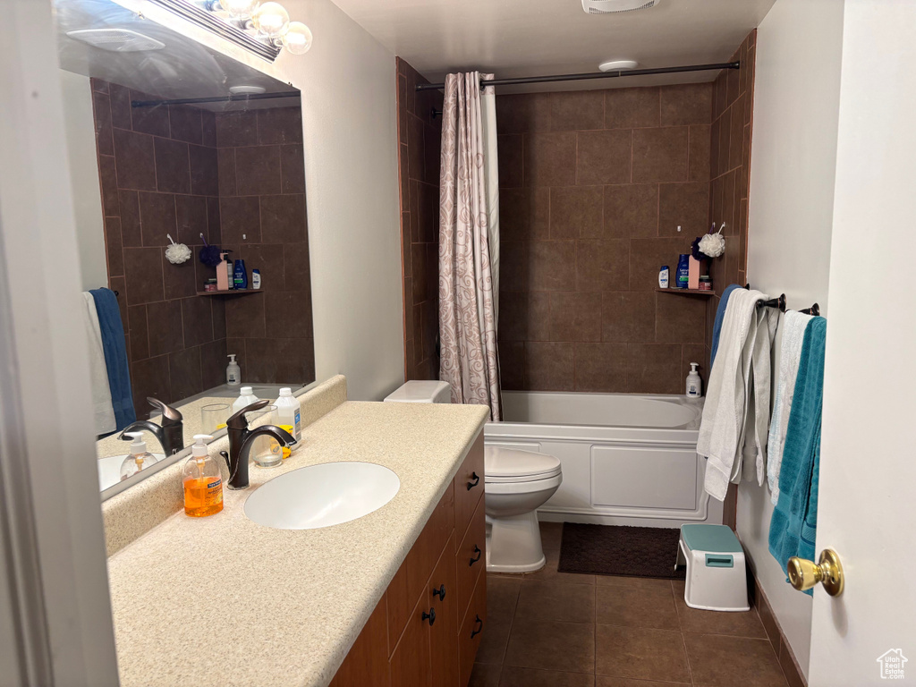 Full bathroom featuring vanity, toilet, tile patterned flooring, and shower / tub combo