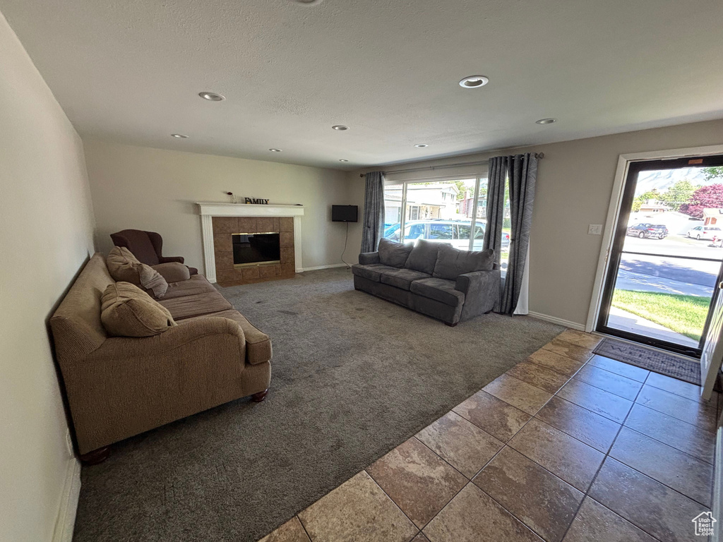 Carpeted living room with a tile fireplace, baseboards, and recessed lighting