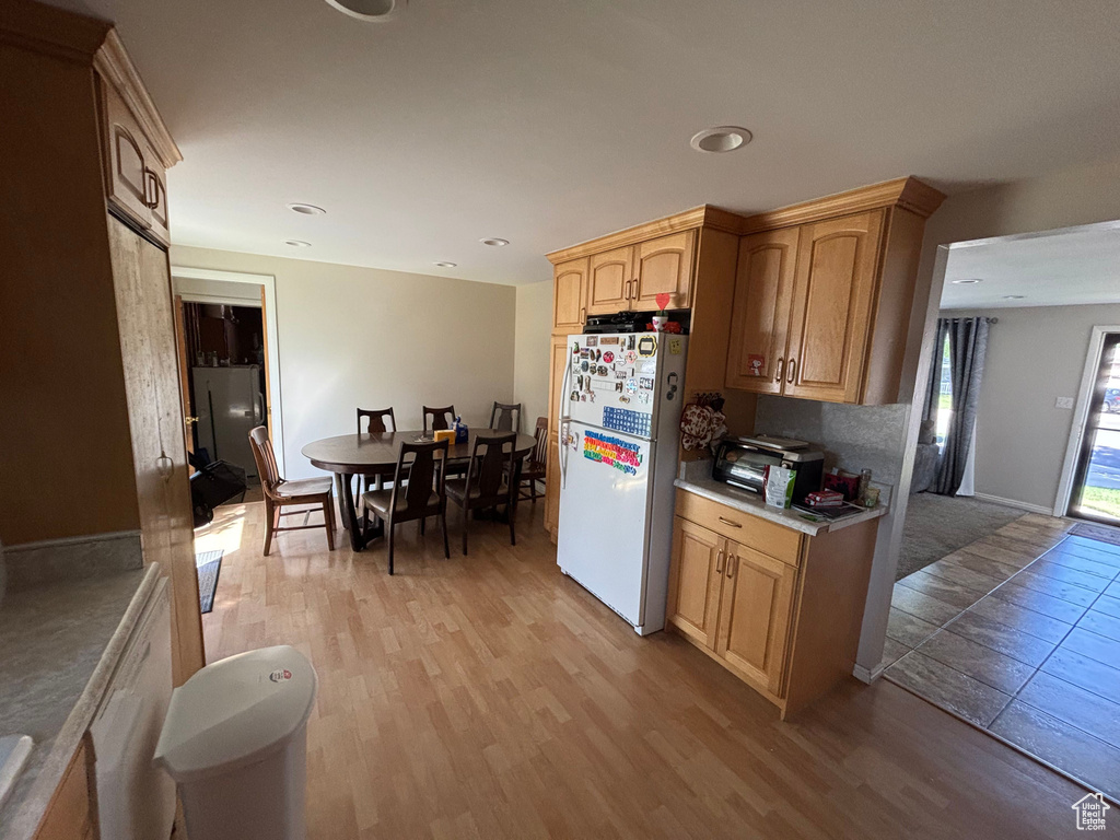Kitchen featuring freestanding refrigerator, light wood finished floors, light countertops, recessed lighting, and light brown cabinetry