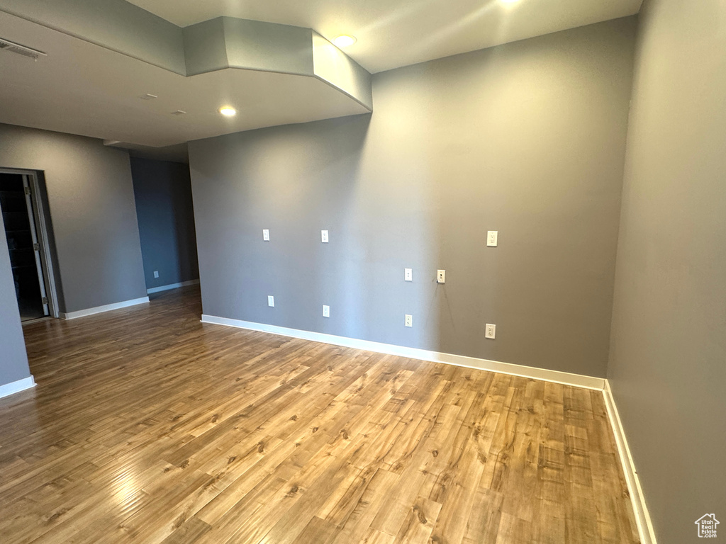 Empty room featuring baseboards, wood finished floors, and recessed lighting
