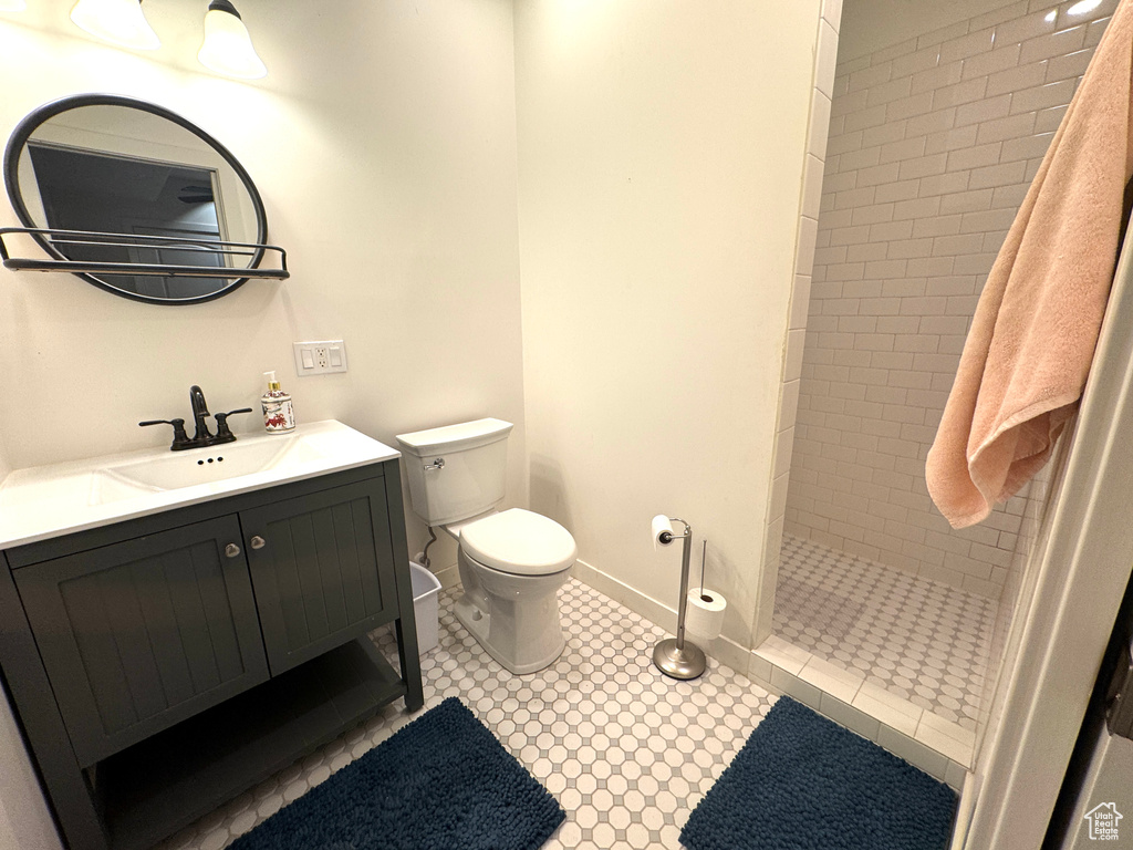 Bathroom with toilet, walk in shower, and vanity