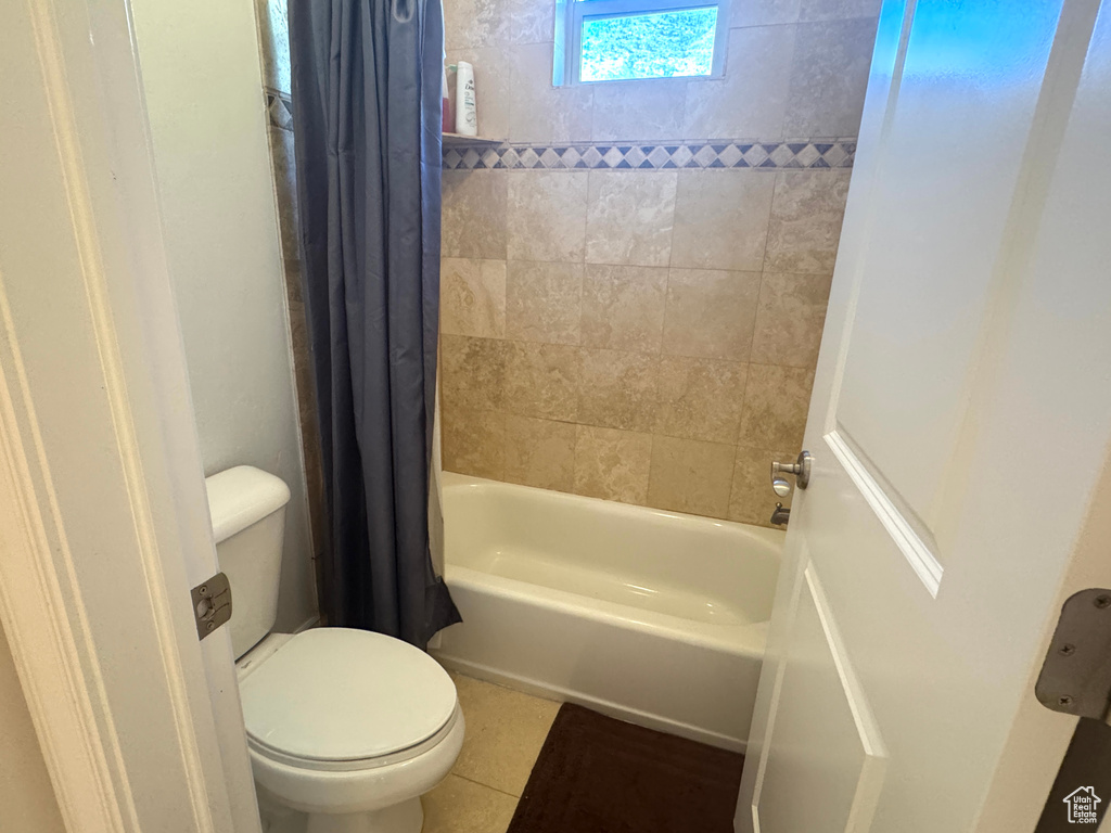 Full bathroom featuring toilet, shower / tub combo, and tile patterned floors