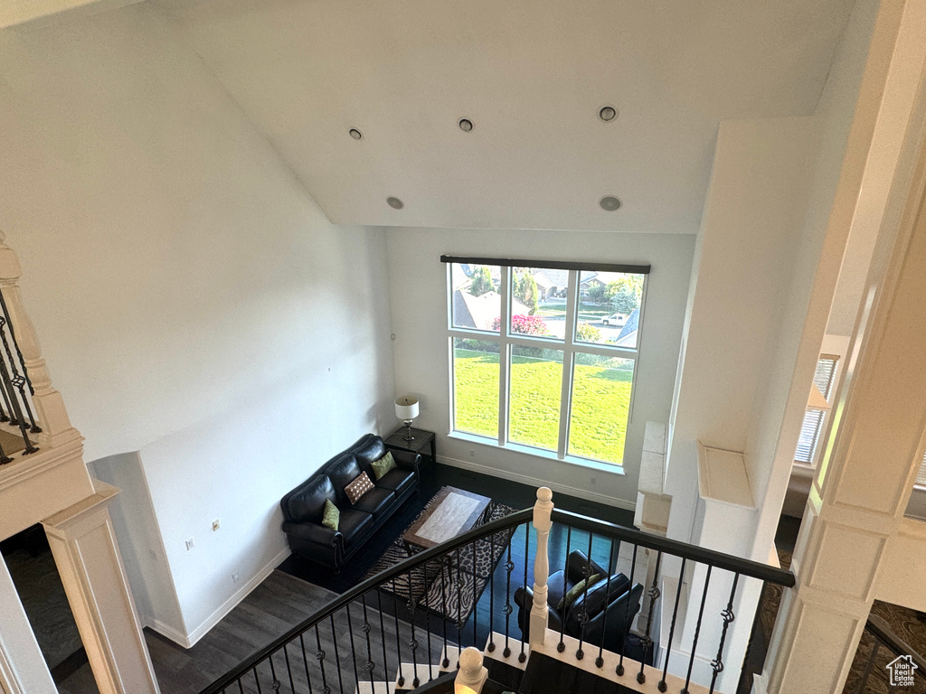 Stairs featuring baseboards, high vaulted ceiling, and wood finished floors
